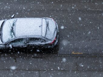 Black car on the road under the snow in spring in New Zagreb, Croatia