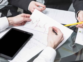 close-up-two-businesspeople-analyzing-report-office