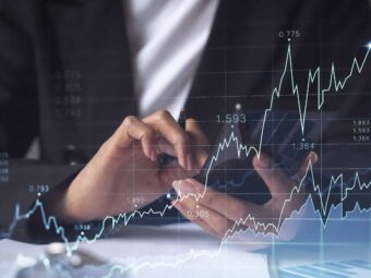 A woman financial trader in formal wear is checking the phone to sign the contract to invest money in stock market. Internet trading and wealth management concept. Forex hologram chart.